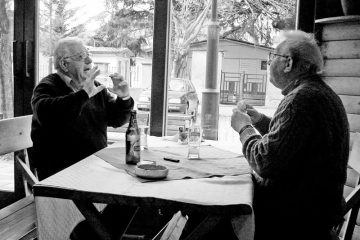 Two friends having a lively conversation over drinks