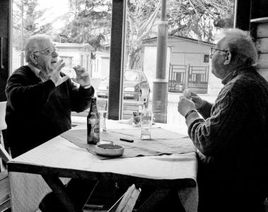 Two friends having a lively conversation over drinks