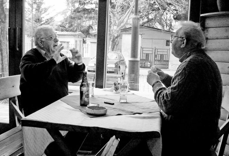 Two friends having a lively conversation over drinks